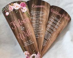 three wooden wedding programs with pink flowers on them