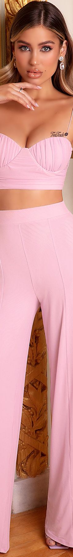 a woman in a pink outfit with her hands on her hips