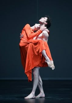 two ballerinas are hugging each other on stage