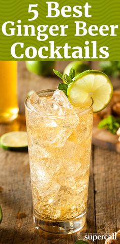 a glass filled with ice and limes on top of a wooden table next to sliced ginger