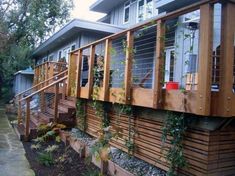 an outside view of a house with plants growing on the deck and balcony railings