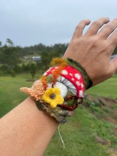 a hand is holding onto a bracelet with flowers on it