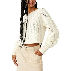 a woman with long black hair wearing a white sweater and beige skirt is posing for the camera