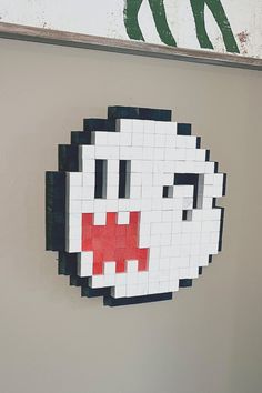 a white and black face made out of legos on the wall next to a sign