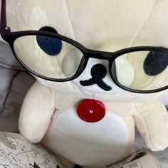 a white teddy bear wearing glasses and reading a book