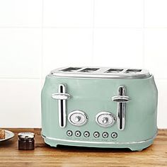 a green toaster sitting on top of a wooden counter