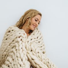 a woman wrapped in a large chunky blanket