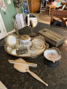 an assortment of decorative items on a table in a room with green walls and furniture