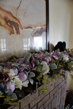 flowers are arranged in baskets on the mantle