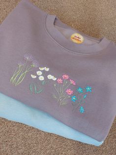 This cosy wildflower jumper is dusty lilac in colour (other colours also available). It features 4 beautifully embroidered images of a flowers perfect for those spring days or gardening enthusiasts. The jumper is professionally embroidered by myself in my home studio in Staffordshire. The jumpers are a unisex fit, please check the size guide if unsure If it helps I am a size 12 and wear a Medium Flower Jumper, Embroidered Jumper, Dusty Lilac, Summer Sweatshirt, Spring Sweater, Embroidered Clothes, Embroidered Sweatshirt, Spring Day, Embroidered Sweatshirts