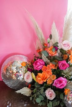 an arrangement of flowers and disco balls on a table