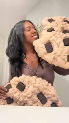 a woman holding two cookies in front of her face