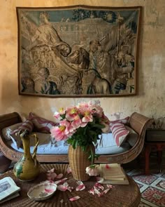 a vase filled with pink flowers sitting on top of a table next to a couch