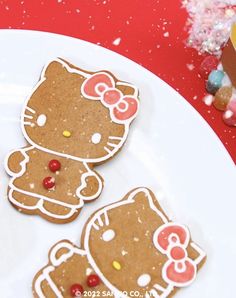 three hello kitty cookies on a white plate