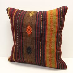 a colorful striped pillow sitting on top of a white table