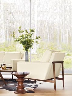 a living room filled with furniture and a vase full of flowers on top of a table