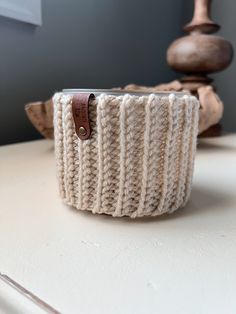 a white knitted cup holder sitting on top of a table