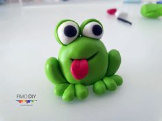 a green toy frog sitting on top of a table