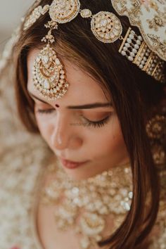 a woman wearing a gold and white bridal outfit