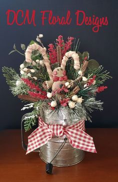 a metal bucket filled with flowers and candy canes