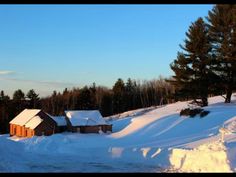 a snow covered hill with houses and trees in the background