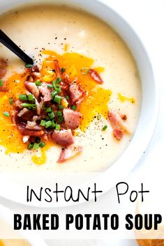 a bowl of baked potato soup with bacon and green onions in it, on a white surface