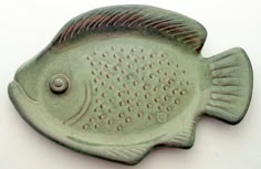 a ceramic fish shaped dish sitting on top of a table