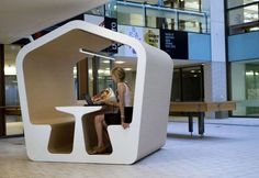 a woman sitting at a table with a laptop computer in it's center area