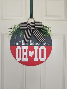 a door hanger that says in this house we oh 10 with a bow on it