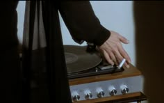 a person with their hand on top of a record player