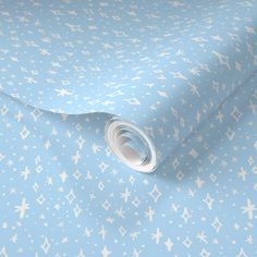 a blue and white wallpaper with small crosses on the ground, as well as a roll of tape