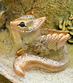 a glass figurine sitting on top of a rock