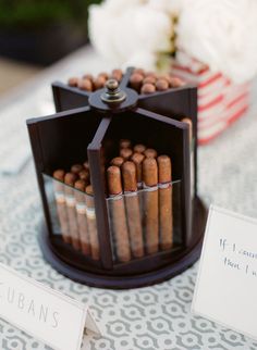 there are many cigars on the table with place cards in front of them,