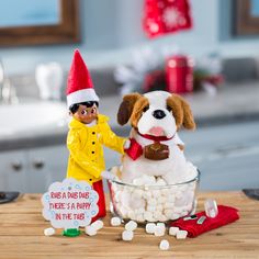 there is a dog that is in the bowl with marshmallows on the table