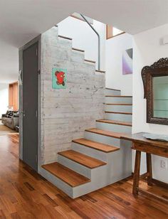 there is a mirror and some stairs in this house with wood floors on both sides