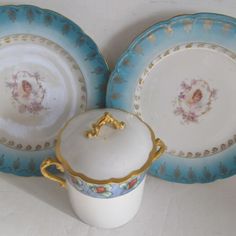 three blue and white dishes with gold trim