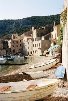 several boats are parked on the shore near some buildings