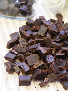 chocolate chunks are sitting on a table next to some flowers