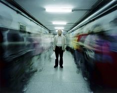 a man standing in the middle of a long hallway