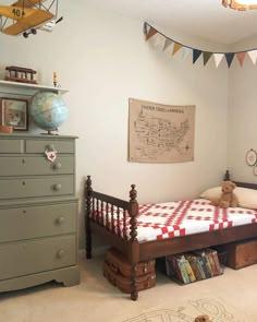 a bedroom with a bed, dresser and toy chest