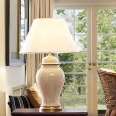 a white lamp sitting on top of a wooden table