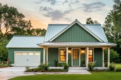 a green house with white trim and two garages