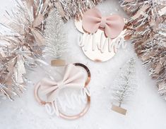 two hair clips with bows on them sitting next to silver tinsel and christmas trees