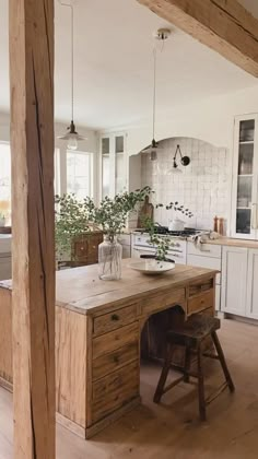 an open kitchen with wooden floors and white cabinets in the background is a dining area