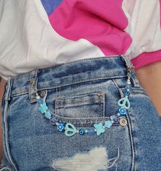 the back of a woman's jean shorts with blue beads and charms on them