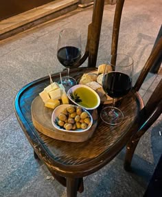 a wooden table topped with wine glasses and food