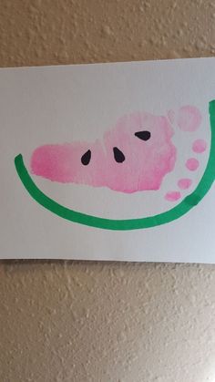 a piece of paper with a watermelon painted on it's side and the bottom part of its face