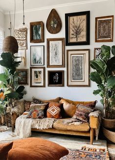 a living room filled with lots of pictures on the wall and plants in vases