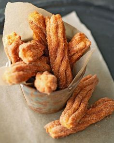 some fried food is sitting in a small bowl on a napkin next to a fork