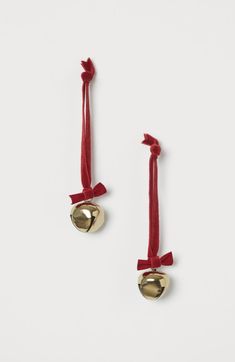 pair of earrings with bell and red ribbon